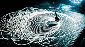 Pêndulo a desenhar linhas caóticas na areia que gradualmente se transformam em círculos geométricos perfeitos, representando a transição da ansiedade para a clareza mental e foco absoluto.